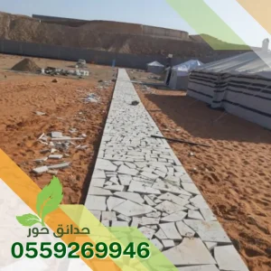 ممر طويل من الحجر العشوائي فوق رمل بتوزيع قطع غير منتظم في الرياض